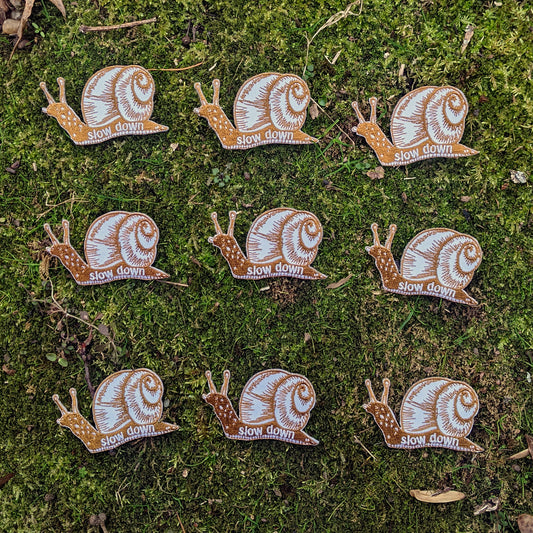 iron-on patch | slow down snail - brown 1.6" x 2.6"