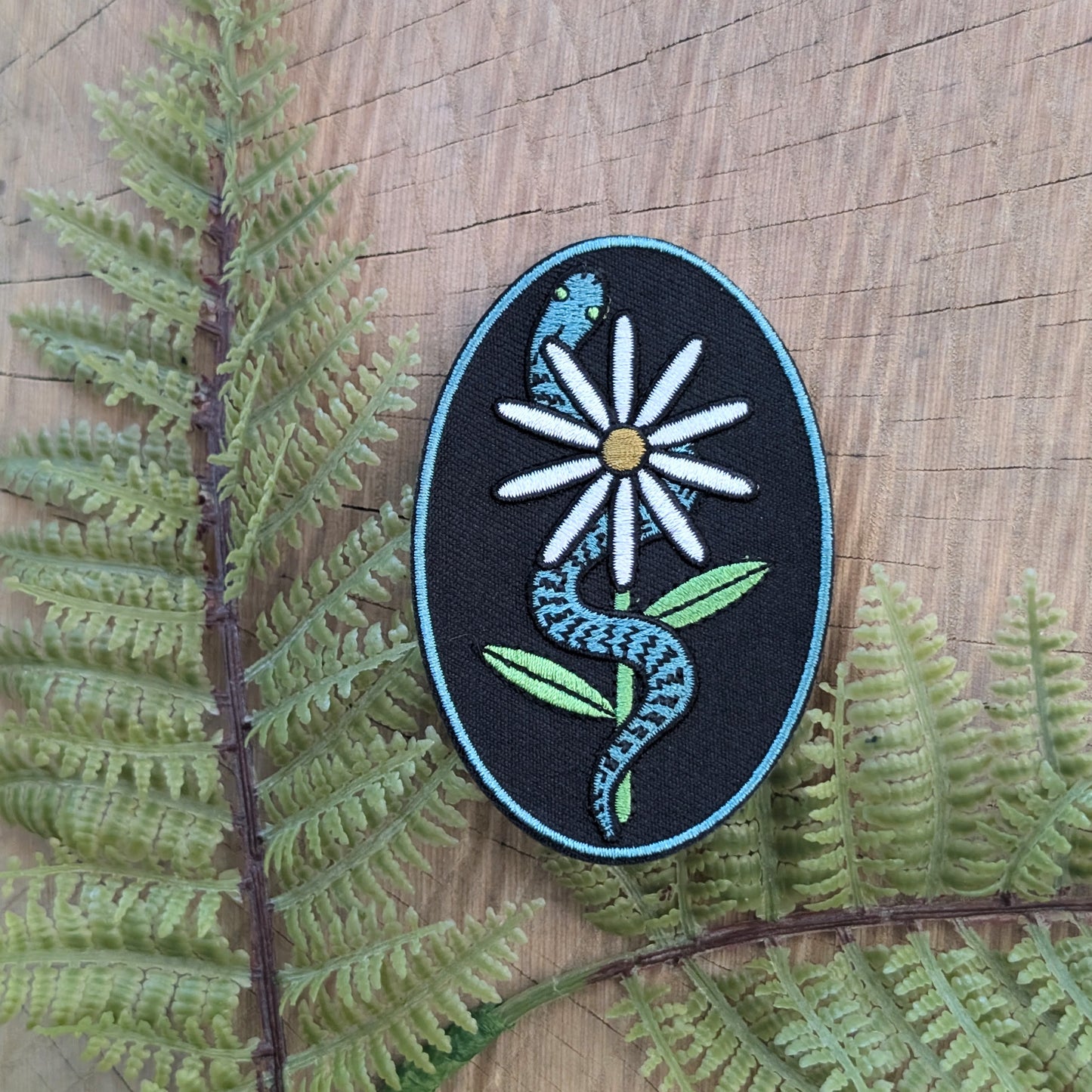 iron-on patch | serpent with daisy - snake & flower on black