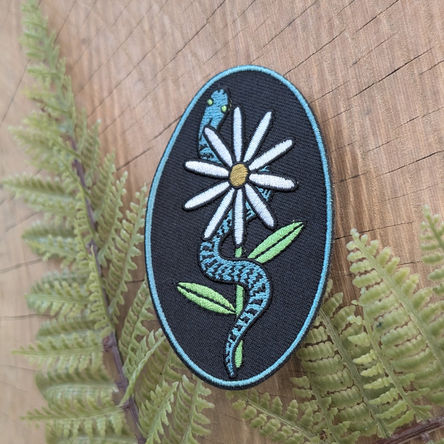 iron-on patch | serpent with daisy - snake & flower on black