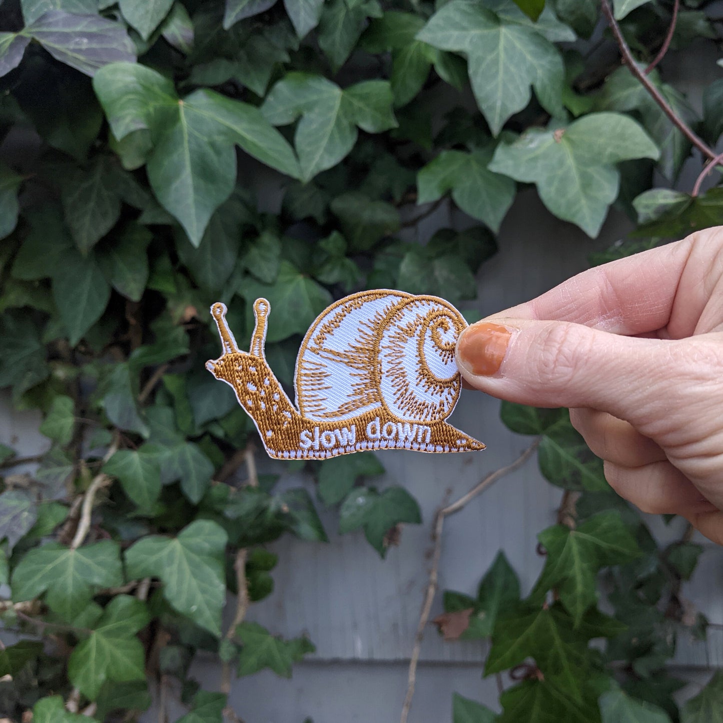 iron-on patch | slow down snail - brown 1.6" x 2.6"